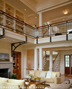 a living room filled with furniture and a fire place under a stair case next to a fireplace