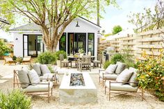 a patio with chairs, tables and a fire pit