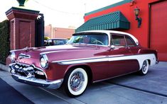 an old car parked in front of a building