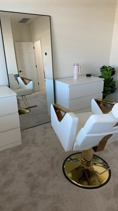 a white chair sitting on top of a carpeted floor next to a wall mounted mirror