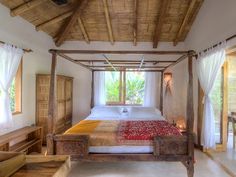 a large bed sitting under a wooden ceiling