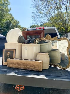 there are many vases and other items on the back of a pickup truck bed