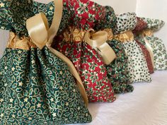 four bags with bows are lined up on a table