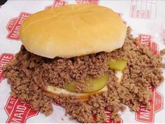 a hamburger sitting on top of a pile of ground beef