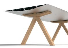 a white surfboard sitting on top of a wooden stand next to a black and white object