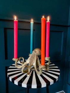 an octopus candle holder on a table with three candles