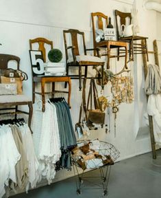 a room filled with lots of different types of clothes and furniture on display in front of a white wall