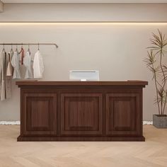 an empty room with clothes hanging on the wall and a desk in front of it