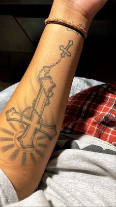 a person with a cross tattoo on their arm