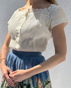 This vintage 1950s blouse looks like something you would find made by hand in Provence many moons ago. It is so beautifully made of a crisp cotton-blend poplin, with pintucks through the front of the blouse, and crochet lace trim. Darts and shaping seams create a fitted shape with a nipped waist, but it can also be worn more loosely fitting (as shown). It looks cute tied in the front as well! It closes down the front with pretty mother-of-pearl-esque orb buttons, which look really luxe. The Vint Provence Fashion, 1950s Blouse, Skirt Measurements, Blouse Measurement, Crochet Lace Trim, Gathered Skirt, Loose Blouse, Full Skirt, Vintage 1950s