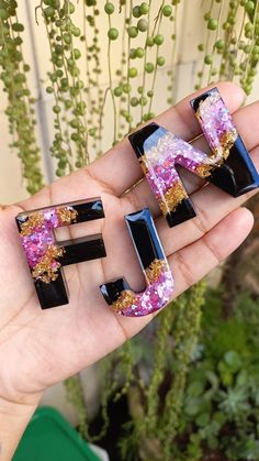 the letter f is made out of glass and decorated with gold flecks on it