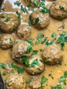 meatballs and gravy with parsley on top in a skillet, ready to be eaten