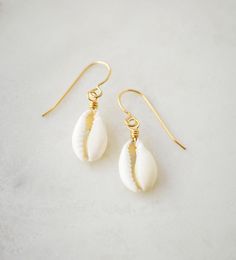 Never leave the sea behind with these natural Cowrie Shell earrings! Handcrafted with creamy-white cowrie shells, these earrings are more than just jewelry--they're a symbol of strength and prosperity. Designed to transport you to sunny shores, these dainty dangles will give you summer vibes all year round.  We hand-make each earring to order in your choice of sterling silver or 14k gold filled earring hooks. Since each shell is natural there will be slight variations from one piece to the next, Cowrie Shell Earrings, Summer Beach Jewelry, Cowrie Shell Necklace, Cowrie Shells, Sterling Silver Jewelry Handmade, Gold Filled Earrings, Cowrie Shell, Shell Earrings, Earring Hooks