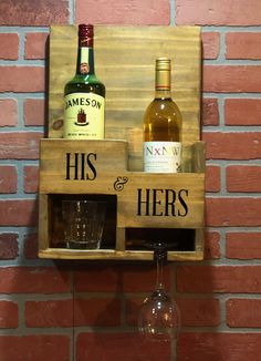 two bottles of wine are sitting on a wooden shelf next to a glass and bottle holder