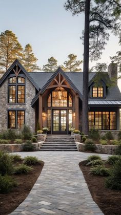 a large house with lots of windows and stone walkway leading up to the front door