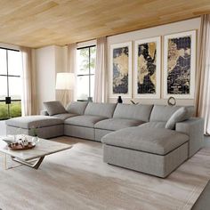 a living room with a large sectional couch and coffee table in front of two windows