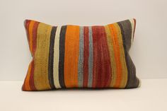 a multicolored striped pillow sitting on top of a white table