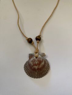 Handmade sea shell necklace crafted with a scallop shell, hemp cord, and wooden beads. Necklace With Shells Diy, Homemade Shell Necklace, Scallop Shell Necklace, Hawaiian Shell Jewelry, Sea Shells Necklace, Handmade Shell Necklace, Beaded Shell Necklace, Sea Shell Necklace Diy, Cord Necklace Diy