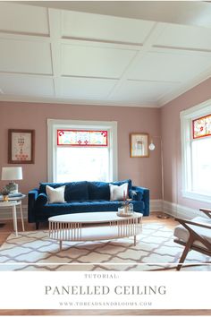 a living room with pink walls and blue couch