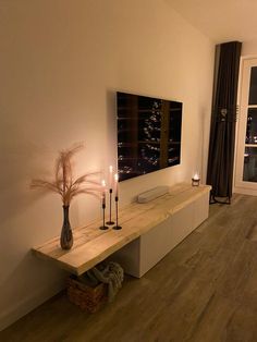 a living room filled with furniture and a flat screen tv on top of a wooden shelf