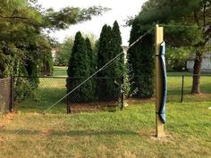 an outdoor batting cage with trees in the background