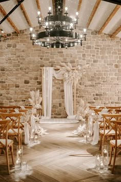 an indoor wedding venue set up with wooden chairs and white draping on the ceiling