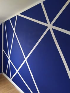 an empty room with blue walls and white lines painted on the wall behind it,