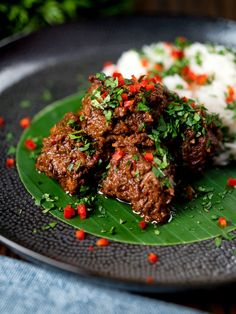 meatballs and rice on a plate with garnishes in the middle, ready to be eaten