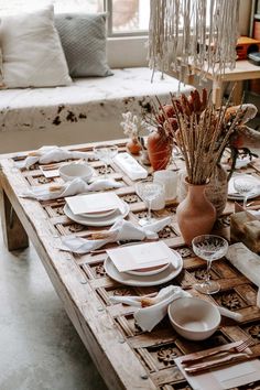 the table is set with dishes and place settings