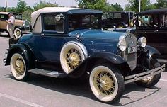 an antique car is parked in a parking lot