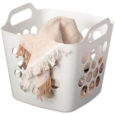 a white laundry basket filled with towels and blankets