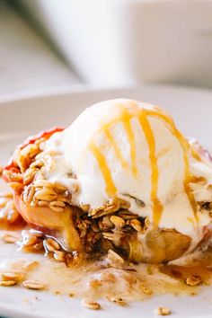 an ice cream sundae on a plate topped with nuts and caramel drizzle