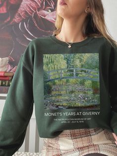 "D E S I G N \"My garden is my most beautiful masterpiece. I work at my garden all the time and with love. What I need most are flowers. Always. My heart is forever in Giverny, perhaps I owe it to the flowers that I became a painter.\" -Claude Monet > Our sweatshirts here at [For Wednesday's Child] are made on demand, especially for you! Each garment is hand printed using a direct-to-garment printer by our production partner, and shipped directly from our partners to you! *Colors may vary slight Classical Art Dark, Monet Japanese Bridge, Painting Tee Shirts, Water Lilies Art, Dark Academia Art, Japanese Bridge, Water Lilies Painting, Clothes Art, Art Teacher Gifts