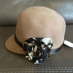 Brand New With Tag. Icing Tan/Brown Hat With Flower On Side. Never Been Worn. 100% Wool. Chic Brown Cloche Hat For Spring, Brown Cloche Hat With Short Brim, Brown Brimmed Cloche Hat One Size, Brown Brimmed Cloche Hat, One Size Fits Most, Brown Brimmed Cloche Hat, Brown Casual Cloche Hat One Size, Chic Adjustable Brown Cloche Hat, Brown Visor Hat One Size Fits Most, Brown Brimmed Felt Hat One Size