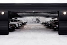 an open garage with cars parked in the parking lot and lights on either side of it