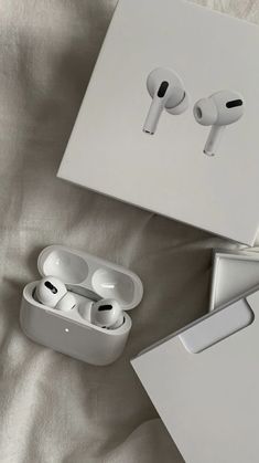 two apple airpods sitting next to each other on a bed