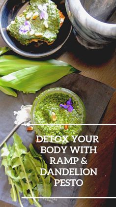 a wooden table topped with plates and bowls filled with green food covered in pesto