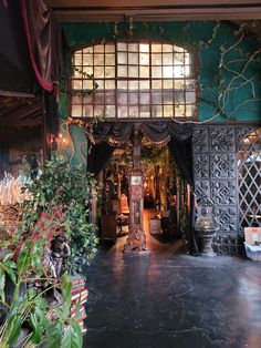 the entrance to an ornately decorated building with lots of greenery and flowers on display