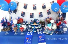 a blue table topped with lots of desserts and balloons