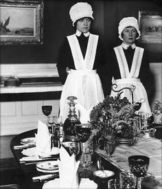 an old black and white photo of two women in aprons