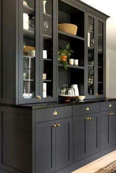 a kitchen with black cabinets and gold knobs