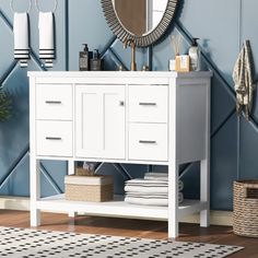 a bathroom with blue walls and white furniture, including a mirror on the wall above the sink