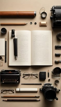 an assortment of office supplies laid out on top of a table next to a typewriter