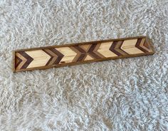 a wooden arrow shaped object sitting on top of a white carpet