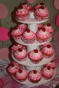 cupcakes are stacked on top of each other with cherries in the middle