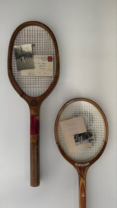 two tennis racquets are hanging on the wall next to each other,