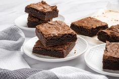 four plates with brownies on them sitting on a table