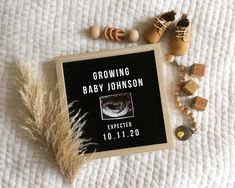 a baby's birth announcement on a bed next to wooden toys and beads, including a pacifier