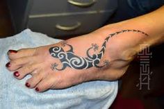 a woman's foot with a lizard tattoo on it