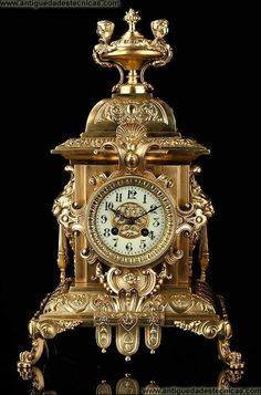 an ornate gold clock is shown against a black background